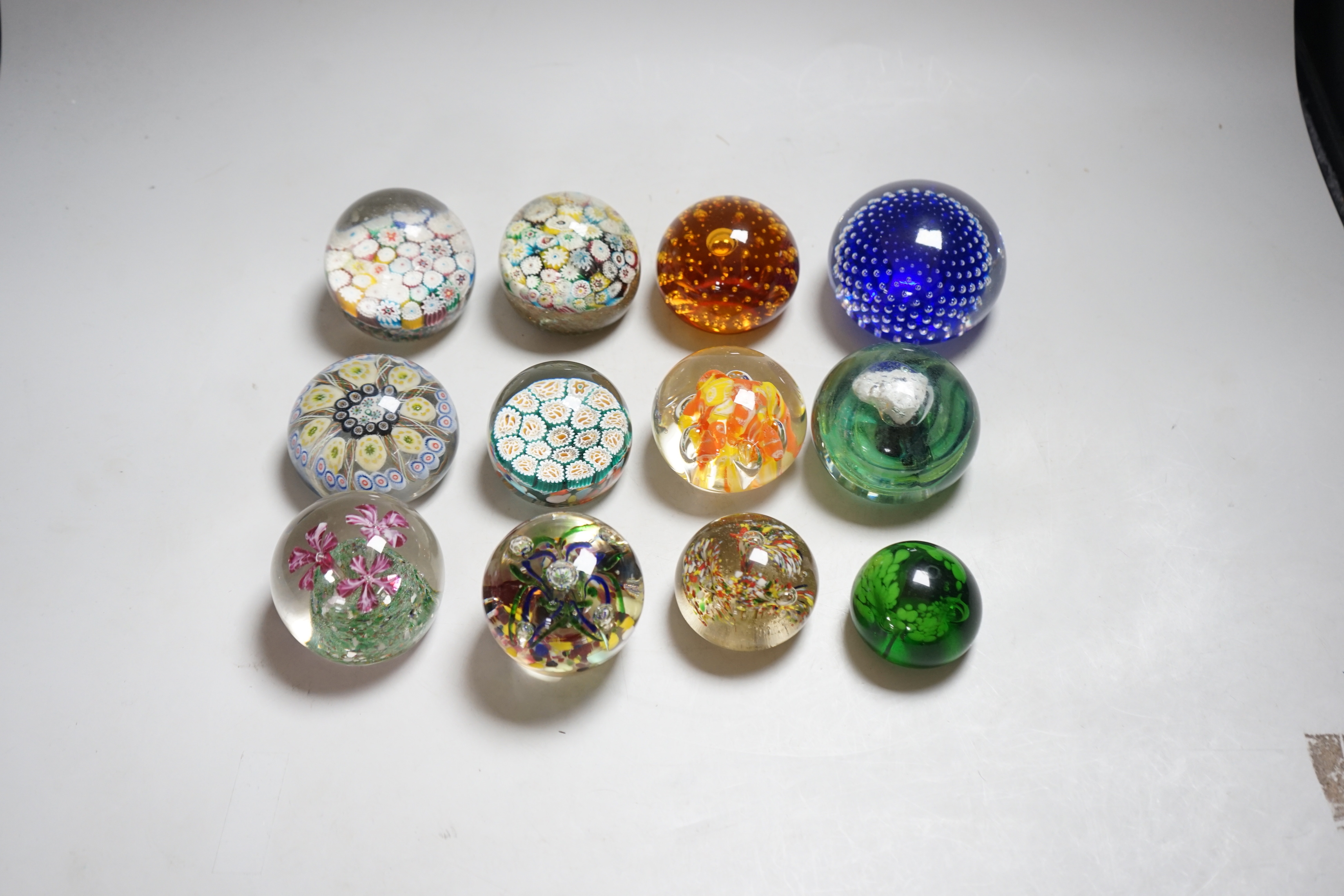 Twelve 20th century paperweights including Bohemian and Chinese examples, close packed millefleur canes, lamp work, etc.